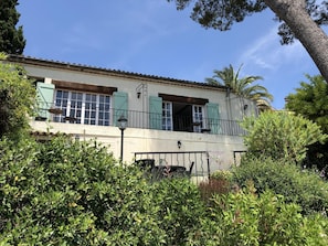 Villa's french doors and balcony with terraces below, and a private sunny garden