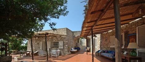 Vista del trullo rivestito in pietra locale con scaletta romantica in pietra 