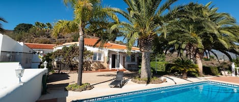 Haus, Palmen und Pool unter dem blauen Himmel Andalusiens