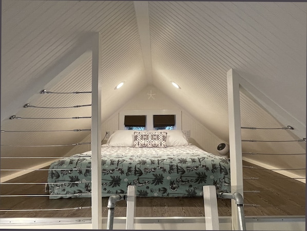 The sleeping loft with comfy queen bed – a serene place to hang out and chill.