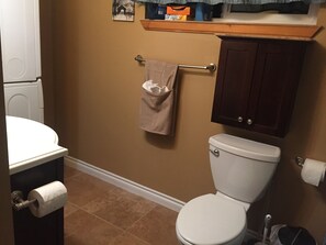 Downstairs bathroom with front loading washer and dryer.