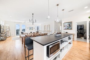 Microwave and pots and pans fill the shelving under the island bar.