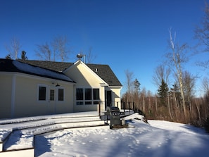 A different view of back of house and deck in winter
