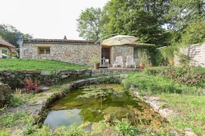 Rear view of gite and natural water source from garden