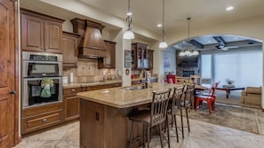 Fully stocked gourmet kitchen featuring extra seating at the bar