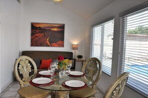 Spacious dining area, table with 4 chairs. Back - queen size sofa.