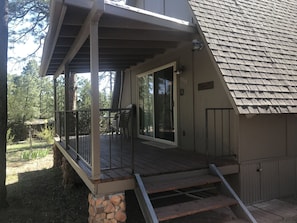 Front porch with table and chairs. Lots of trees on acre lot.