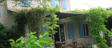 façade sud avec sa jolie tonnelle et sa table de jardin