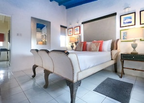 Kas di Amor's inviting bedroom features coastal decor, sea life watercolor paintings, air conditioning, and a cooling ceiling fan.