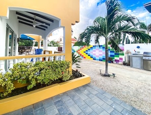 Kas di Amor's patio offers a welcoming retreat with a bistro set, pub table and stools, ceiling fan, and direct ocean views.