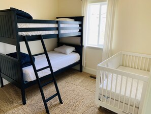 Bedroom off master  has a crib and two twin beds. This room also has toys/books.