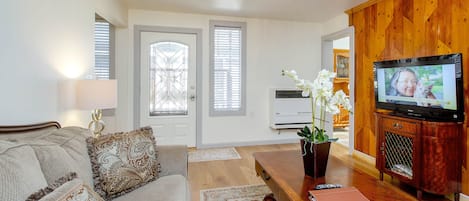 Living room with HDTV. Showing front door and windows.