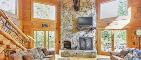 Spacious great room features large stone fire place & plenty of seating.