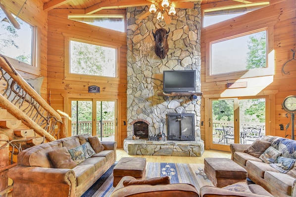 Spacious great room features large stone fire place & plenty of seating.