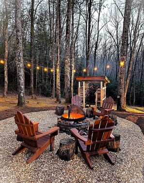 Newly redone backyard fire-pit with party lights at night