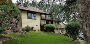 Home, surrounded by flowers and oaks