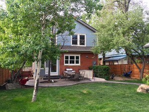 Spacious backyard with concrete patio, outdoor seating and grill.