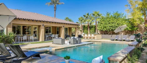 Impressive backyard with resort-style amenities such as comfortable chaise lounge seating for 6, outdoor fire pit, al fresco dining for 12 and built in BBQ with mini fridge