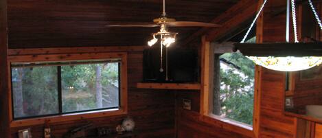 The living room has a high ceiling and lots of natural light. 