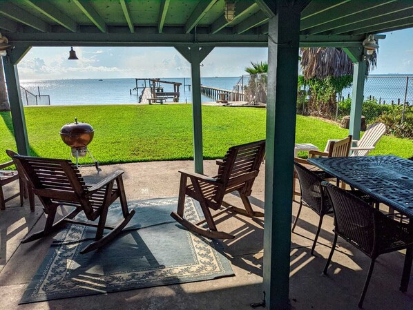 Covered patio with waterfront view. Sit down and enjoy the breeze.