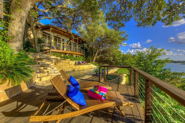 Pool/spa/decks built into the hillside banks of Lake Travis among the trees.