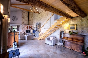 Salon avec une hauteurs sous plafond de plus de 5 mètres - Canapé et fauteuils - TV avec barre de son et lecteur DVD - Insert à bois (bois fournis)