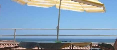 la terrasse avec vue sur la mer méditerranée et la plage de sable fin.