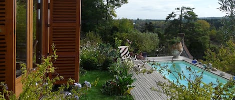 la piscine avec sa plage en bois réservée uniquement pour les locataires