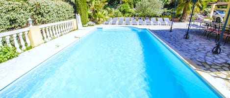 Grande piscine avec escalier et échelle. Elle est protégée par une alarme.