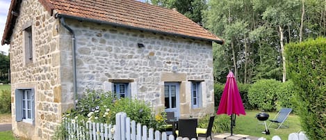 Maison en pierre du pays avec sa terrasse en bois plein sud