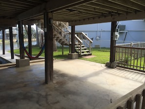 Covered patio downstairs w/ table and seating