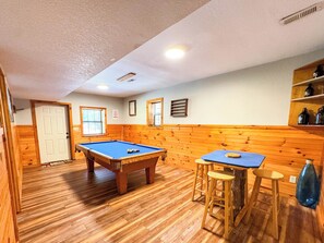 the lower level game room features a pool table and card table