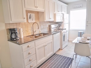The kitchen is complete with everything from cookware to plates and a coffee maker
