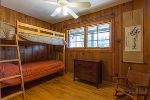 A rustic and charming second bedroom with two bunks.