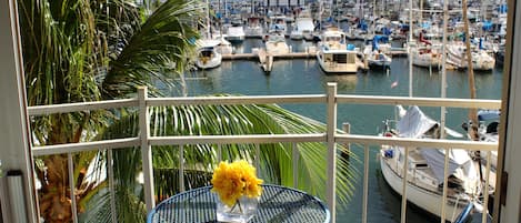 View from the quaint balcony boasting a table and two chairs. 