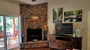 Wood burning fireplace in living room. 55" Smart TV for streaming favorite shows