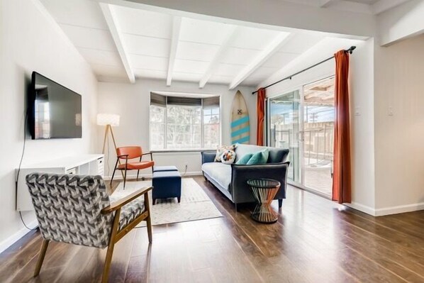 Living Room has large wall mounted TV, Convertible Sofa Futon Sleeper, Chair, Large Window with seating over looking Pool & Jacuzzi