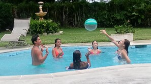 Kids enjoy pool games in 15' x 30' ft heated pool. Fountain in background.
