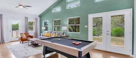 Living area with pool table and views of the rear of the property.