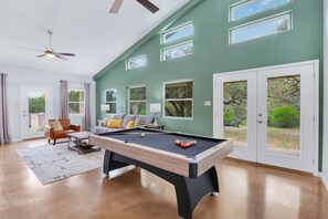 Living area with pool table and views of the rear of the property.