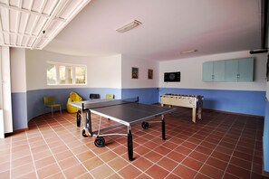 Zona ocio con mesa de ping pong, futbolín y diana de dardos 