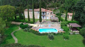 Front view of the villa and the swimming pool surrounded by the lawn, the jacuzz