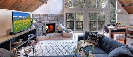 Large, light-filled Great Room, kitchen and dining area with a forest view.