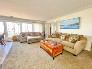 Living area with 3 large couches, lots of natural light, tv & great lake views!