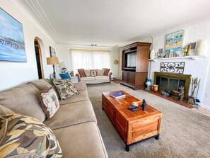 Living area with 3 large couches, lots of natural light, tv & great lake views!