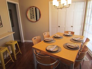 Closer view of dining seating area, laundry and fun counter bar with two stools