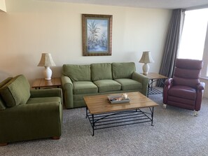 Living room has a sleeper sofa and overlooks the ocean. 