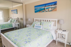 Queen bed in master with mirrored closet doors to capture the ocean views