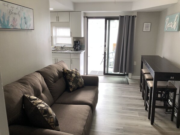 Living room has new queen sofa bed, table & stools, floor, new sliding door. 