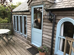 The Boathouse entrance and balcony with outdoor seating for 4